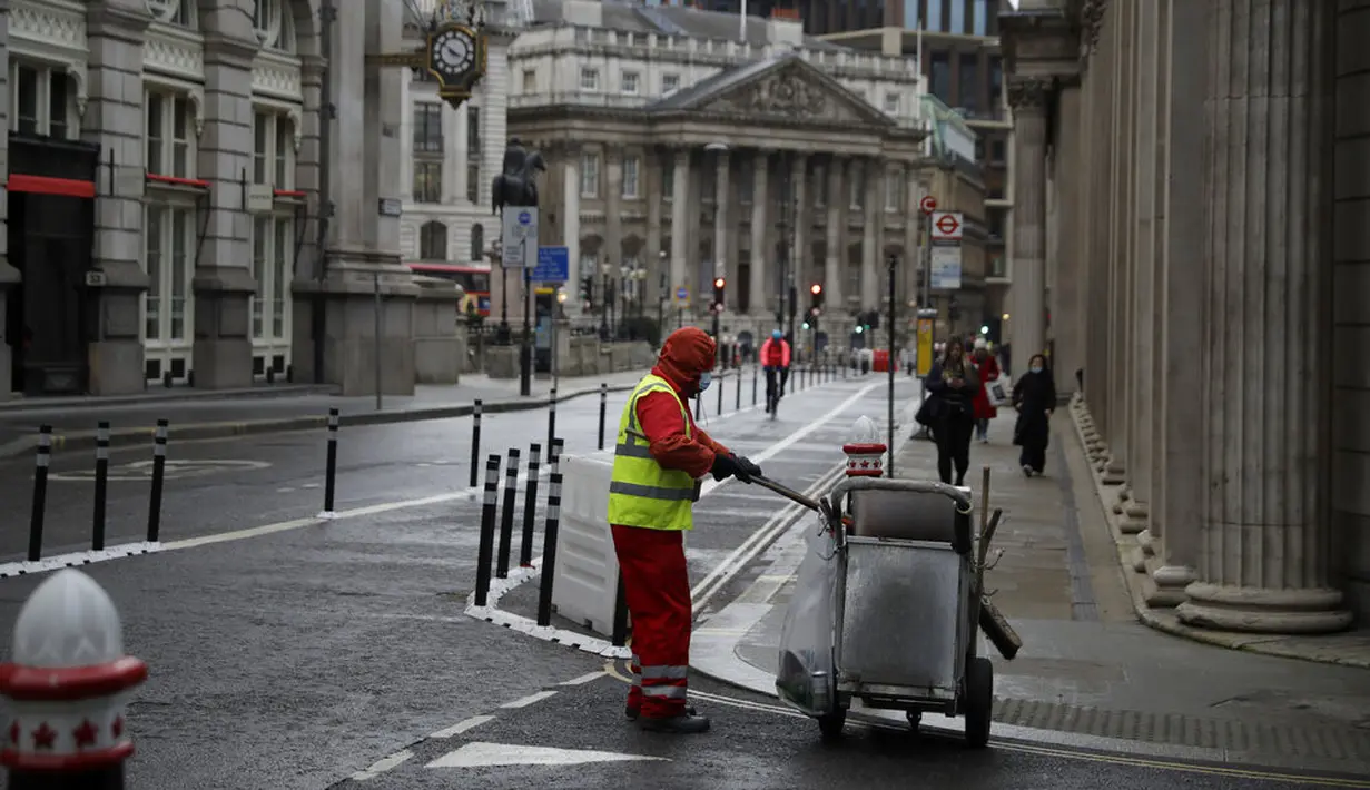 Seorang pembersih jalan bekerja pada pagi pertama penerapan lockdown nasional ketiga di Kota London, Inggris, 5 Januari 2021. Penerapan lockdown nasional ketiga di Inggris berlangsung selama enam minggu. (AP Photo/Matt Dunham)