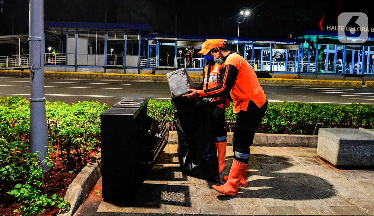 Pasukan oranye mengumpulkan sampah di tengah Pandemi Covid-19, Jakarta, Jumat (8/5/2020). Semenjak diberlakukan Pembatasan Sosial Berskala Besar (PSBB) yang diterapkan Ibu Kota membuat aktivitas warga berkurang dan jalan menjadi lengang. (merdeka.com/Imam Buhori)