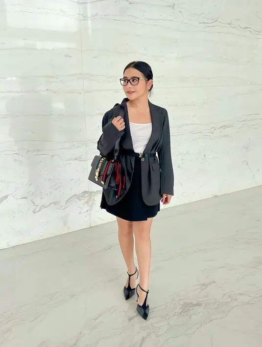 Tampil monokrom, Prilly terlihat stylish sebagai budak korporat dengan jaket kulit dan rok hitam. Paduan tas dan heels-nya bikin terlihat fashionable [@prillylatuconsina96]