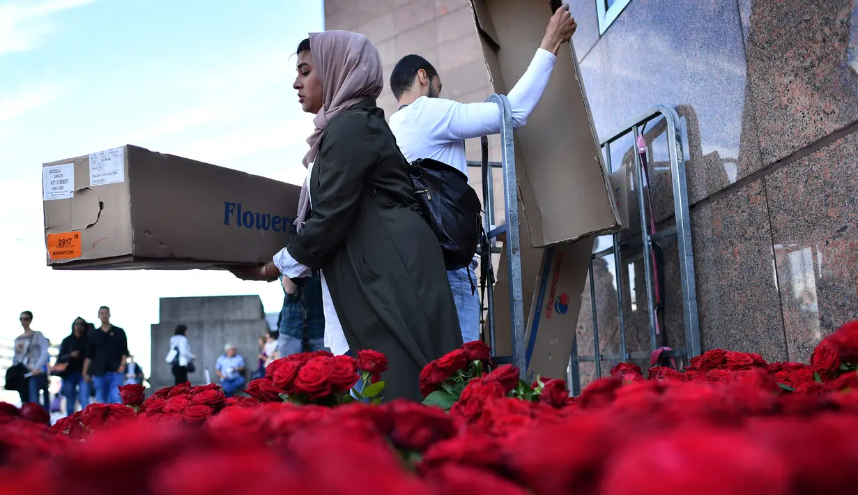 Seorang muslim bersiap membagikan bunga mawar kepada pejalan kaki di London Bridge, Minggu (11/6). Muslim Inggris membagikan ratusan mawar sebagai bentuk solidaritas menyusul serangan teror London yang terjadi pekan lalu. (Ben STANSALL/AFP)