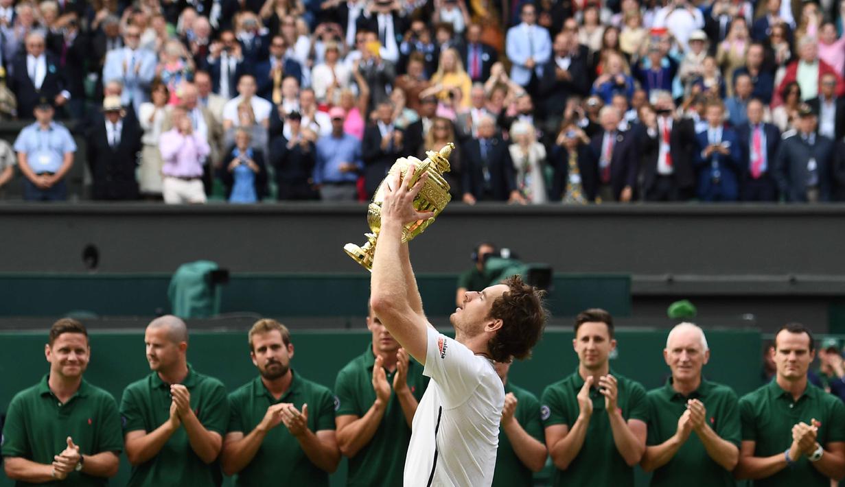 Andy Murray mengangkat trofi Wimbledon usai mengalahkan petenis Kanada,  Milos Raonic pada tunggal putra Wimbledon Championships 2016 di The All England Lawn Tennis Club,  Wimbledon, London, (10/7/2016). (AFP/Glyn Kirk)