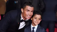 Pemain Real Madrid, Cristiano Ronaldo (kiri) berpose dengan sang putra, Cristiano Ronaldo Jr, pada pemutaran perdana film dokumenter berjudul 'Ronaldo' di Leicester Square, London, Senin (9/11/2015) malam waktu setempat. (EPA/Facundo Arrizabalaga)