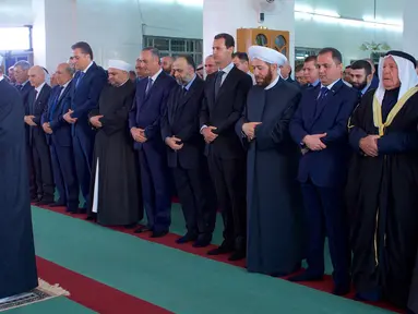 Presiden Suriah, Bashar al-Assad (keempat kanan) melaksanakan salat Idul Adha di Masjid Agung Qara, di wilayah Qalamoun di pinggiran ibukota Suriah Damaskus (1/9). Assad salat didampingi sejumlah pejabat setempat. (AFP Photo/Sana/Handout)
