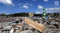 Sebuah papan dengan pesan Kami Rindu Rumah Kami dipasang pasca gempa bumi dan tsunami di pinggir Jalan Trans Sulawesi, Palu, Sulawesi Tengah, Kamis (4/10). (Liputan6.com/Fery Pradolo)
