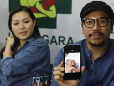 Sammy Simorangkir dan Viviane menunjukkan foto anak pertama mereka saat jumpa pers di rumah sakit kawasan Jatinegara, Jakarta, Jumat (24/8). Sammy dan Viviane dikaruniai anak laki-laki. (Liputan6.com/Herman Zakharia)