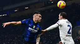 Penyerang Inter Milan Lautaro Martinez (kiri) menyundul bola melewati bek Cagliari Diego Godin pada laga lanjutan Liga Italia pekan ke-17 di Guseppe Meazza, Senin dini hari WIB (13/12/2021). Inter Milan menang telak 4-0 atas tim tamu Cagliari. (Miguel MEDINA / AFP)