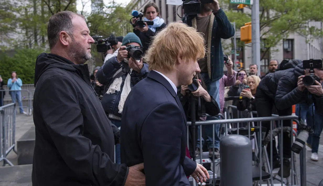 <p>Ed Sheeran tiba di Pengadilan Federal Manhattan dengan diam dan kepala tertunduk, melintasi kerumunan kamera dan wartawan yang berada di luar. (AP Photo/Brittainy Newman)</p>