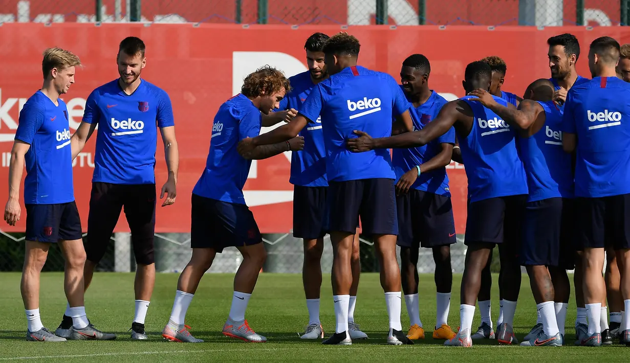 Penyerang baru Barcelona, Antoine Griezmann disambut rekan-rekannya saat tiba mengikuti latihan di Joan Gamper, Barcelona (15/7/2019). Barcelona akan menghadapi Chelsea pada pertandingan pramusim. (AFP Photo/Lluis Gene)