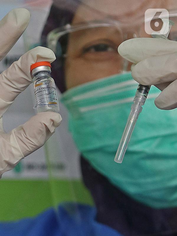 Petugas vaksinator menunujukkan vaksin CoronaVac dari SinoVac di Rumah Sakit JatiSampurna, Bekasi, Jawa Barat, Kamis (28/01/2021). Rumah Sakit JatiSampurna melakukan Penyuntikan dosis kedua vaksin COVID-19 untuk para tenaga medis dan tenaga kesehatan yang bertugas. (Liputan6.com/Herman Zakharia)