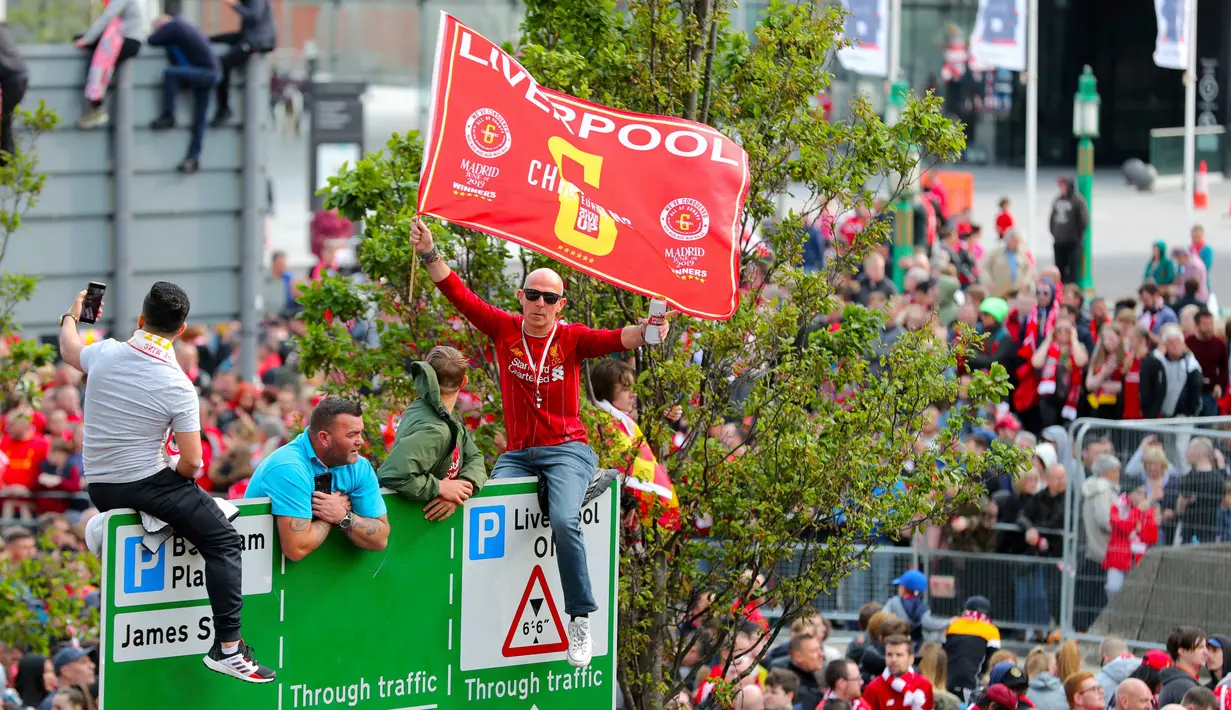 Suporter menyambut kedatangan pemain Liverpool saat parade juara Liga Champions di Liverpool, Inggris (2/6/2019). Ribuan suporter tumpah ruah di jalanan merayakan kemenangan tim kesayangannya meraih piala Liga Champions usai mengalahkan Tottenham di final dengan skor 2-0. (Richard Sellers/PA via AP)