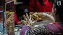 Pengunjung mencoba perhiasan di salah satu stan pameran JIJF 2019 di Jakarta, Kamis (4/4). Pameran ini bertujuan mempromosikan produk-produk perhiasan dengan ciri khas desain etnik budaya dengan menggunakan teknologi masa kini dalam industri perhiasan Tanah Air. (Liputan6.com/Faizal Fanani)
