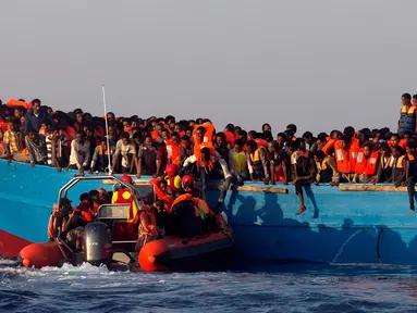 Petugas penyelamat mendekati kapal kayu yang disesaki sejumlah imigran, di lepas panti Libya, Laut Mediterania, Senin (29/8).  Para penjaga pantai Italia berhasil menyelamatkan sekitar 6.500 imigran dari Eritrea dan Somalia. (REUTERS/Giorgos Moutafis)