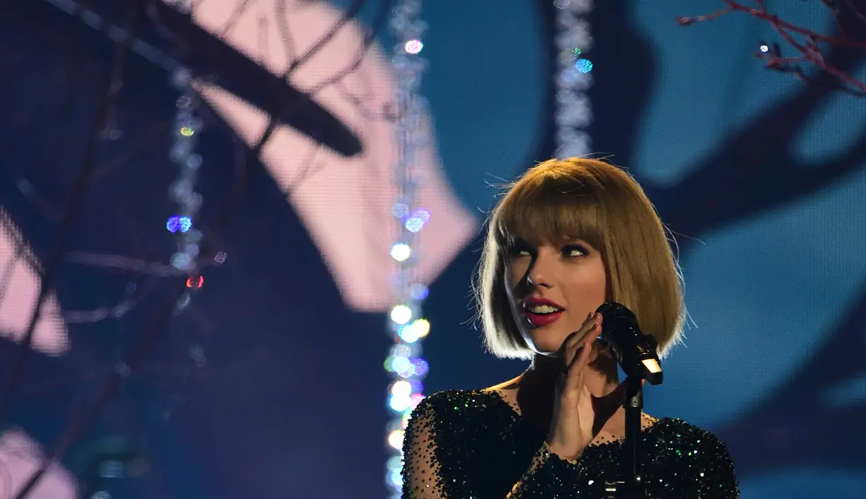 Dilansir dari E! News Taylor Swift terjatuh saat konser di New Jersey. (ROBYN BECK  AFP)