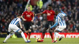 Gelandang Manchester United, Paul Pogba, berusaha melewati pemain Huddersfield pada laga Premier League di Stadion Old Trafford, Rabu (26/12). Manchester United menang 3-1 atas Huddersfield. (AP/Martin Rickett)