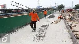 Pekerja mengangkat besi saat pengerjaan proyek penataan ulang Kalijodo, Jakarta, Jumat (18/3). Setelah dihancurkan kawasan dengan luas lahan 2,5 hektar di Kalijodo akan digunakan untuk RPTRA. (Liputan6.com/Gempur M Surya)