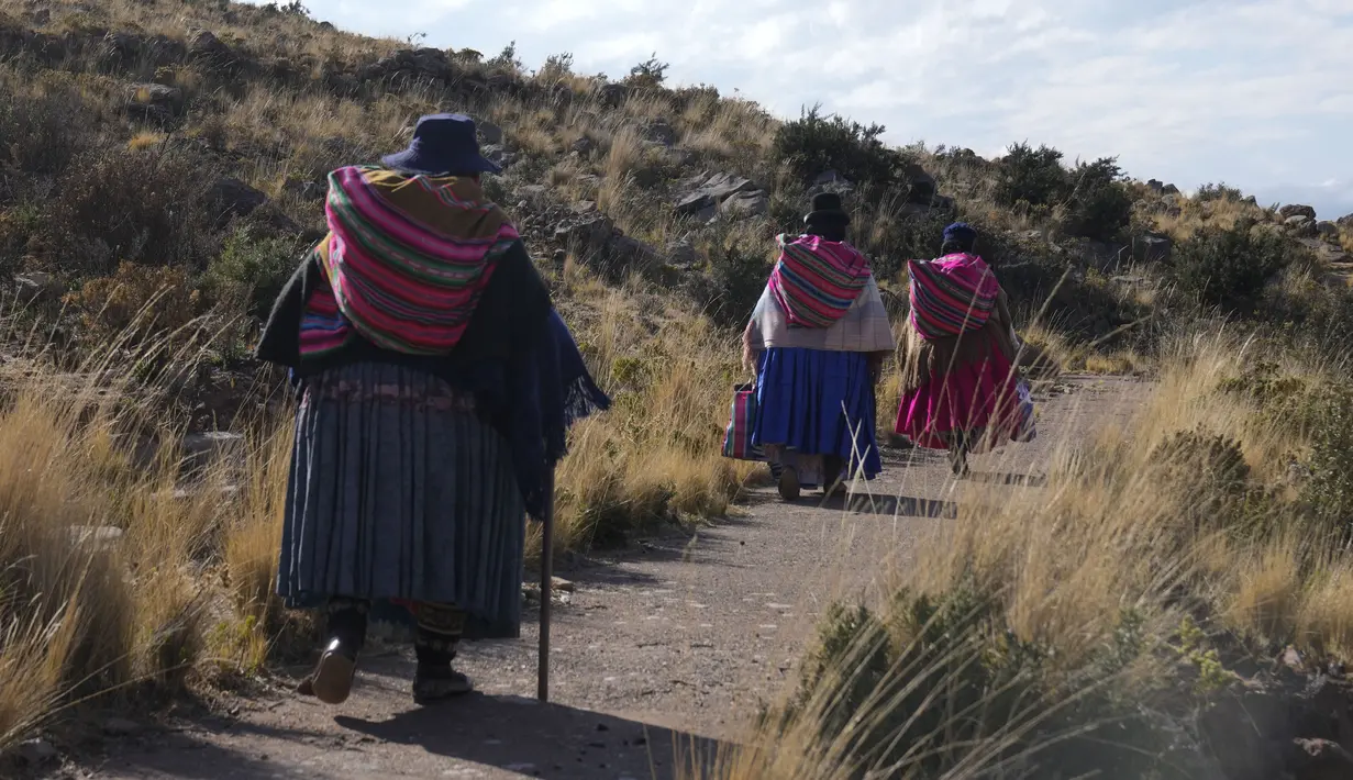 Wanita suku Aymara berjalan ke Gunung Suci Inca Pucara untuk hari doa dan puasa sebagai ritual meminta hujan di Chiquipata, Bolivia, Rabu (16/11/2022). Penduduk dataran tinggi La Paz mengatakan rendahnya curah hujan yang terjadi sejak September membuat mereka tidak bisa menanam kentang, buncis, dan kacang polong. (AP Photo/Juan Karita)