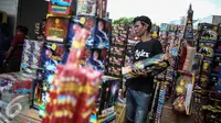 Seorang pedagang membawa kembang api yang dijualnya di Pasar Asemka, Jakarta, Selasa (27/12). Jelang seminggu sebelum perayaan tahun baru 2017 sejumlah pedagang mulai menjajakan berbagai jenis petasan. (Liputan6.com/Faizal Fanani)