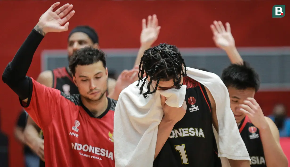 Pemain Timnas Basket Indonesia, Derrick Michel Xzavierro dan rekannya berjalan meninggalkan lapangan usai laga playoff perempat final FIBA Asia Cup 2022 antara Timnas Basket China melawan Timnas Basket Indonesia di Istora Senayan, Jakarta, Senin (18/07/2022). (Bola.com/Bagaskara Lazuardi)