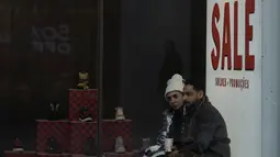 Para pembeli di Oxford Street berjalan melewati tanda obral di etalase toko setelah Bank of England menaikkan Suku Bunga Dasar sebesar 0,5 persen menjadi 3,5 persen di London, Kamis (15/12/2022). Bank Sentral mengkerek suku bunga mereka menjadi 3,5% dari sebelumnya pada level 3% untuk menandai kenaikan suku bunga kesembilan kalinya secara beruntun. (AP Photo/Alastair Grant)