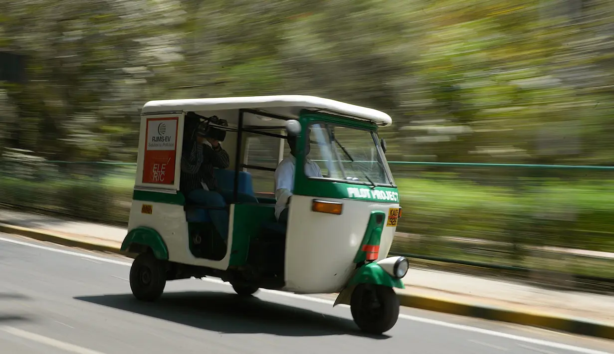 Bajaj 'Eleric-Auto' saat mengangkut seorang kamerawan di Bangalore, India, Sabtu (5/3). Di India 20 persen masyarakatnya menggunakan transportasi umum untuk berpergian dan Bajaj 'Eleric-Auto' salah satunya. MANJUNATH KIRAN / AFP)