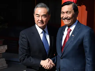 Menteri Luar Negeri China, Wang Yi berjabat tangan dengan Menko Kemaritiman Indonesia, Luhut Pandjaitan sebelum melakukan pertemuan di Wisma Negara Diaoyutai, Beijing. Rabu (24/10). (Daisuke Suzuki/Pool via AP)