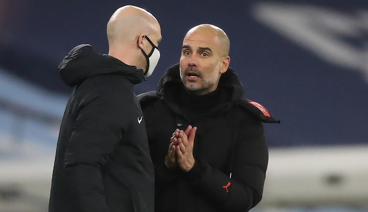 Pelatih Manchester City, Pep Guardiola, berbicara kepada ofisial wasit saat pertandingan melawan West Brom pada laga lanjutan Liga Inggris di Etihad Stadium, Rabu (16/12/2020). Pep Guardiola melakukan protes karena durasi injury time yang dianggap sedikit. (AFP/ Martin Rickett/pool)