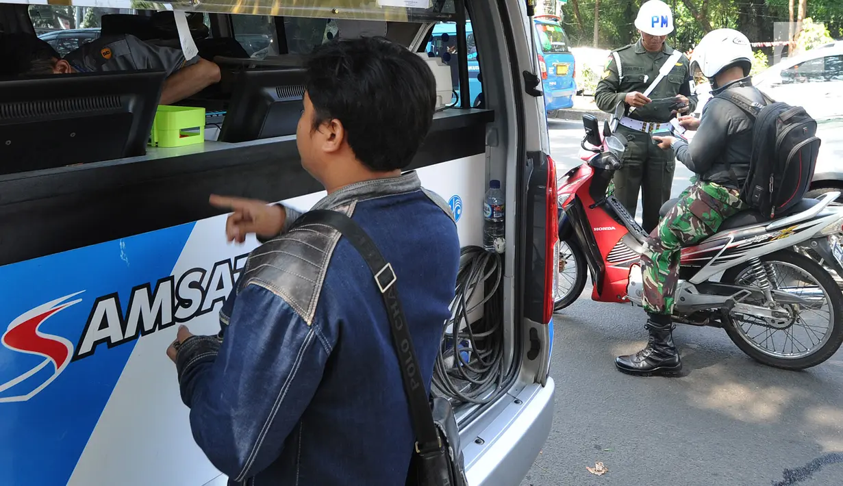 Petugas kepolisian memeriksa kelengkapan dokumen pengendara sepeda motor saat melakukan razia gabungan di kawasan Naggewer,  Bogor, Selasa (18/9). Razia itu menyasar pemilik kendaraan yang belum membayar pajak kendaraan. (Merdeka.com/Arie Basuki)