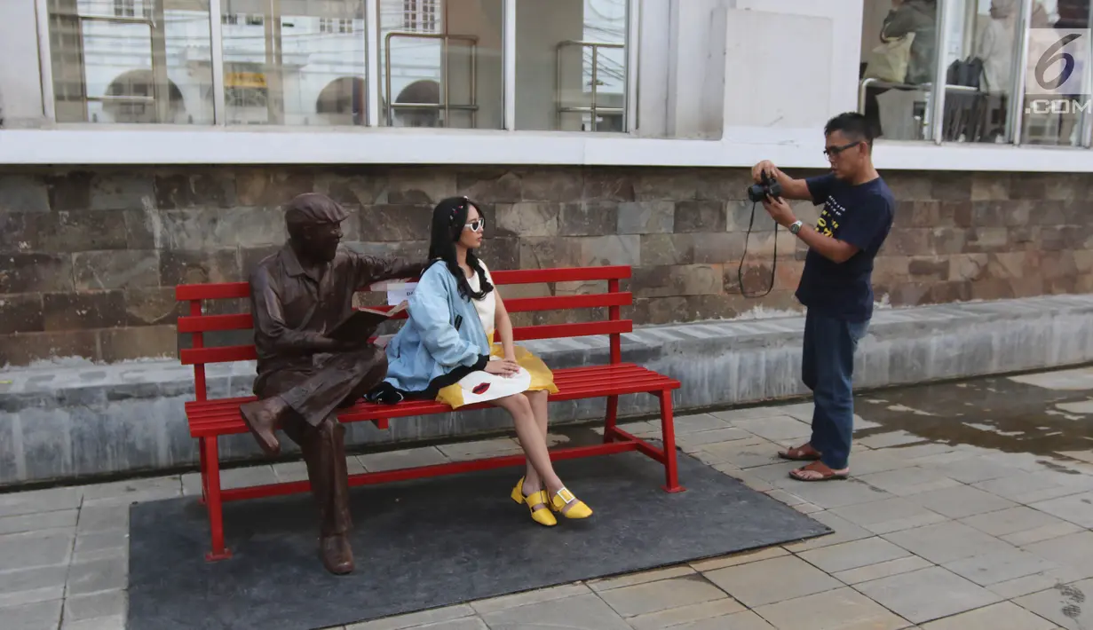 Warga berfoto-foto di kawasan pedestrian Kali Besar, Kota Tua, Jakarta, Rabu (11/7). Proyek revitalisasi Kali Besar itu telah diresmikan dan dibuka untuk umum oleh Wakil Gubernur Sandiaga Uno akhir pekan lalu. (Liputan6.com/Arya Manggala)