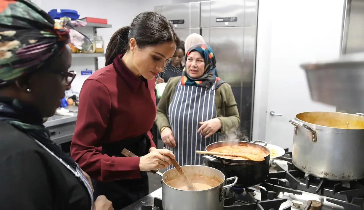 Duchess of Sussex Meghan Markle memasak bersama komunitas Hubb Community Kitchen di London, Inggris (21/11). Kegiatan Istri Pangeran Harry itu untuk melakukan proyek amal. (Chris Jackson/Pool via AP)