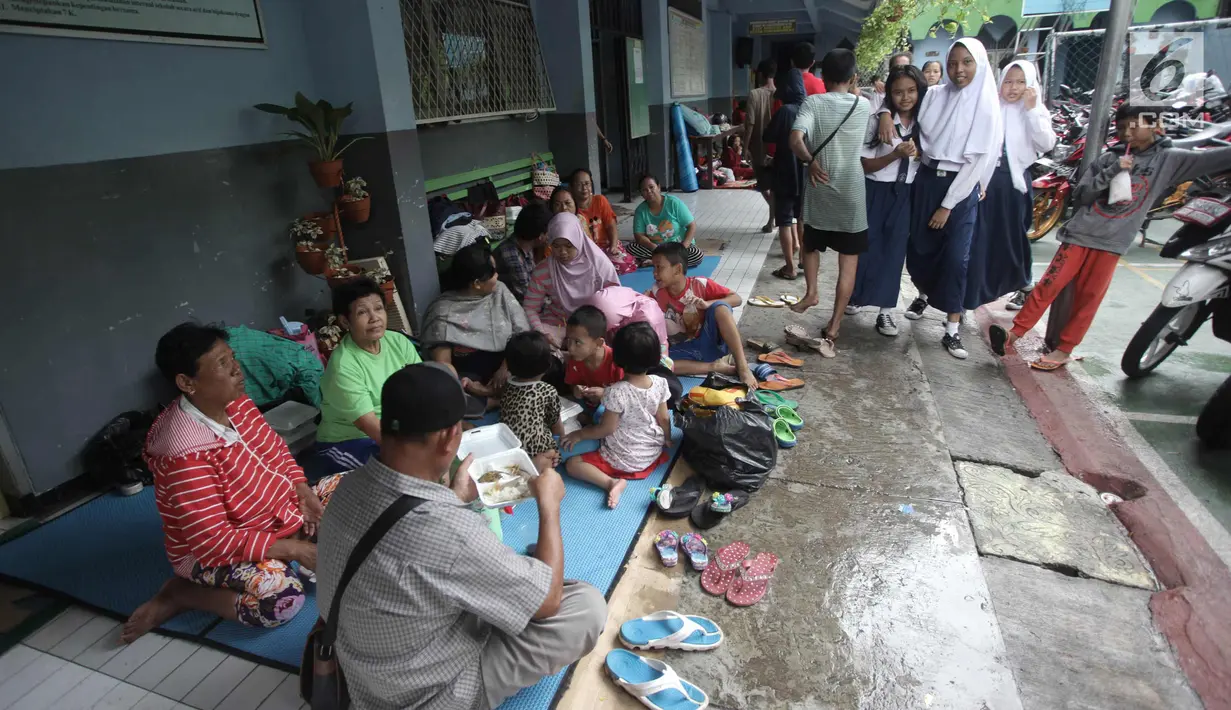 Warga yang rumahnya terendam banjir mengungsi di Gedung SMP Negeri 26, Jalan Kebon Pala, Kampung Melayu, Jatinegara, Jakarta Timur, Selasa (6/2). Sekolah masih tetap masuk, tetapi hanya diabsen karena tidak adanya listrik. (Liputan6.com/Arya Manggala)