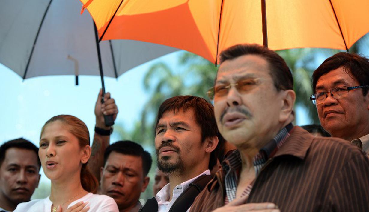 Walikota Manila yang juga mantan presiden Filipina, Joseph Estrada (kedua dari kanan) turut menyambut kedatangan Manny Pacquiao. (AFP PHOTO/NOEL CELIS)
