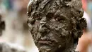 Ekspresi seorang anak yang penuh lumpur saat berpartisipasi dalam perayaan Mud Day atau Hari Lumpur di Wayne County di Nankin Mills Park, Westland, Michigan, AS (11/7). (AFP Photo/Jeff Kowalsky)