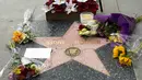 Sebuah catatan dan bunga terlihat pada bintang Sidney Poitier di Hollywood Walk of Fame di Hollywood, California, Jumat (7/1/2022). Poitier, bintang film kulit hitam pertama Hollywood dan pria kulit hitam pertama yang memenangkan aktor terbaik Oscar, meninggal pada usia 94 tahun. (VALERIE MACON/AFP)