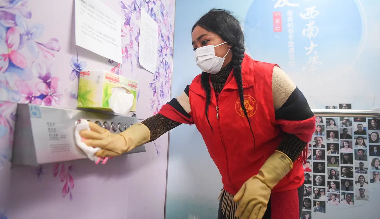 Franca asal Nigeria mendisinfeksi tombol lift di Universitas Barat Daya di Chongqing, China, 18 Februari 2020. Sejumlah pelajar asing di Chongqing ambil bagian dalam kampanye pengendalian epidemi dengan terlibat dalam pekerjaan sukarela. (Xinhua/Wang Quanchao)