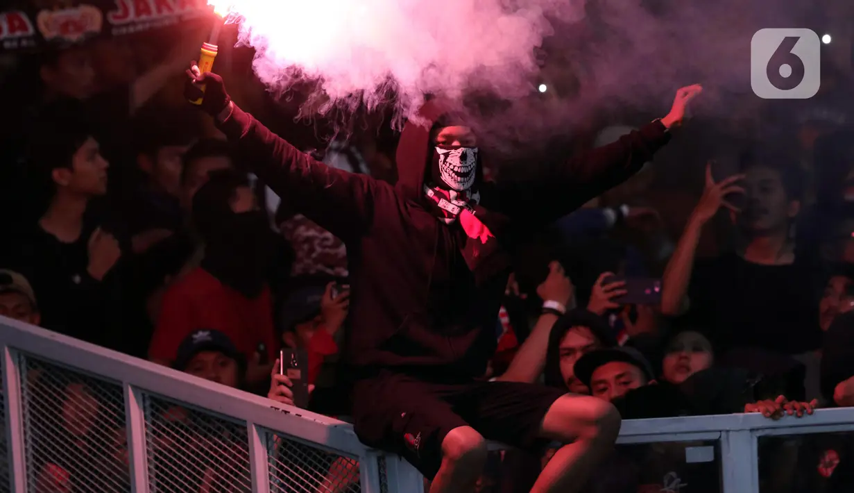 Suporter Persija menyalakan suar saat merayakan HUT ke-91 Persija dan kemenangan atas Persipura di laga lanjutan Shopee Liga 1 Indonesia 2019 di Stadion Utama Gelora Bung Karno, Jakarta, Kamis (28/11/2019). Persija unggul 1-0. (Liputan6.com/Helmi Fithriansyah)