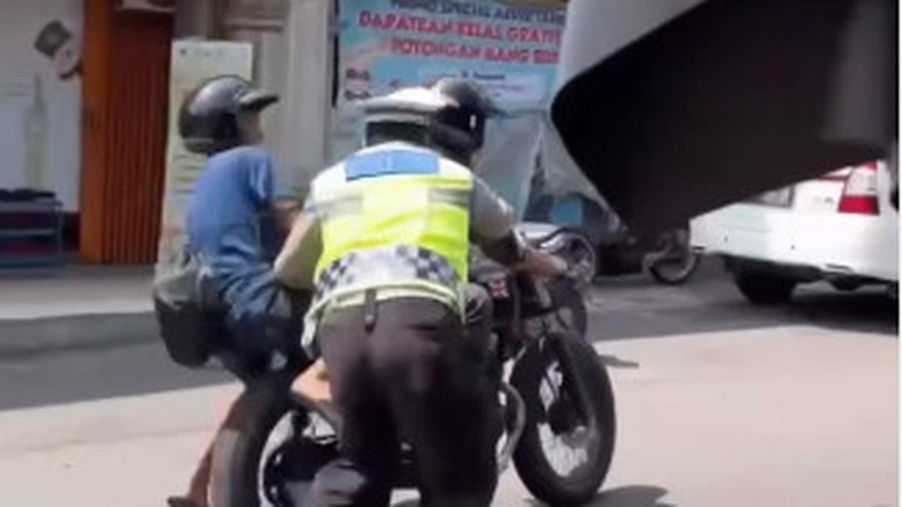 Lantaran kendaraan terus melaju, petugas berseragam itu nampak terseret sejauh 5 meter dari lokasi. <br><br>"Live report banget. Sabar pak polisi, tetap semangat @satlantasjogja," demikian dikutip dari keterangan video.