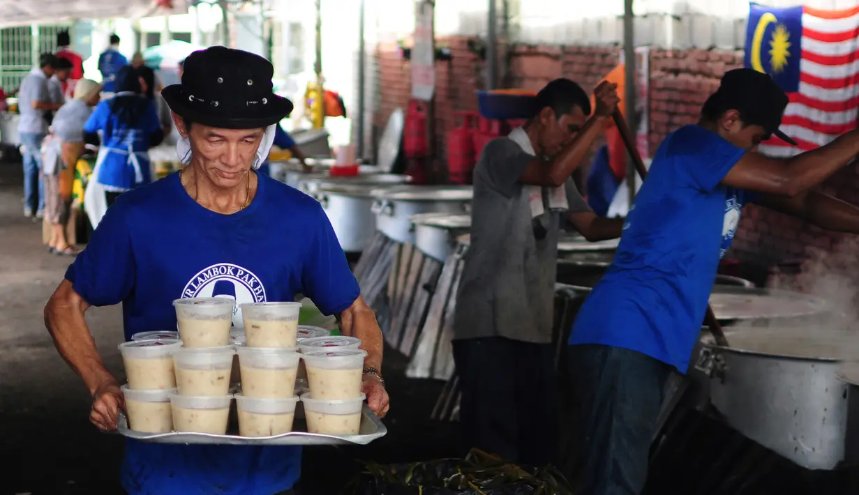 Bubur Lambuk siap untuk didistribusikan di desa Kampung Baru, Kuala Lumpur, Malaysia, Kamis (1/6). Bubur Lambuk biasanya dimasak secara bergotong-royong di masjid-masjid untuk dibagikan kepada jemaah yang ingin berbuka puasa. (AP/Daniel Chan)