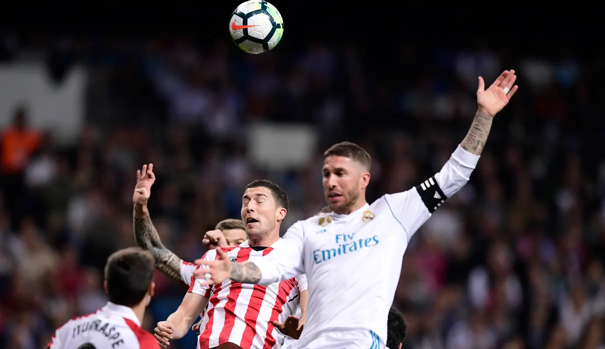 Pemain Athletic Bilbao, Ander Iturraspe dan Oscar De Marcos berebut bola dengan pemain Real Madrid, Sergio Ramos pada pekan ke-33 La Liga di Santiago Bernabeu, Rabu (18/4). Madrid harus puas bermain imbang 1-1 lawan Athletic Bilbao. (JAVIER SORIANO/AFP)