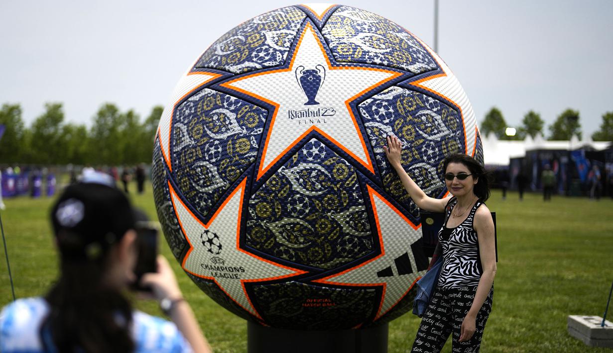 Sejumlah pengunjung berfoto dengan replika bola Liga Champions di Istanbul, Turki, Kamis (8/6/2023). Laga final yang mempertemukan Inter Milan melawan Manchester City akan berlangsung di Atatürk Olympic Stadium, Istanbul, Turki, Minggu (9/6/2023) dini hari WIB. (AP Photo/Khalil Hamra)