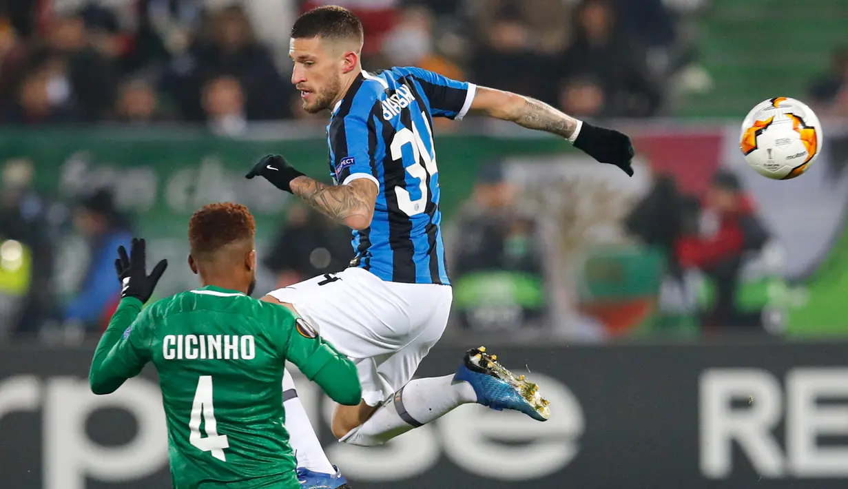Gelandang Inter Milan, Cristiano Biraghi, berebut bola dengan pemain Ludogorets, Cicinho dalam leg pertama 32 besar Liga Europa di Huvepharma Arena, Kamis (20/2/2020). Inter Milan sukses membawa pulang kemenangan usai mengalahkan tuan rumah Ludogorets 2-0. (AP/Vadim Ghirda)