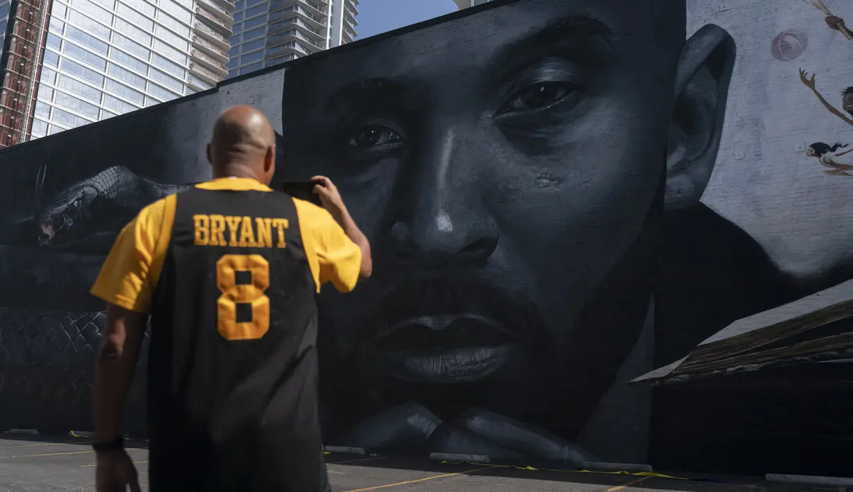 Erikk Aldridge merekam mural yang menggambarkan Kobe Bryant di Los Angeles, Rabu, 24 Agustus 2022.  Berukuran 125 kaki kali 32 kaki, mural tersebut menampilkan potret Bryant, yang meninggal pada tahun 2020 pada usia 41 tahun dalam kecelakaan helikopter. (AP Photo/Jae C. Hong)