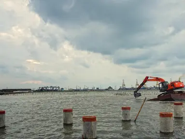 Alat berat mengeruk lumpur dan memasang tiang pancang untuk proyek pembangunan tembok penahan rob ( Giant Wall Sea ) di Kawasan Tambak Lorok Semarang, Jumat ( 12/2). (Gholib)