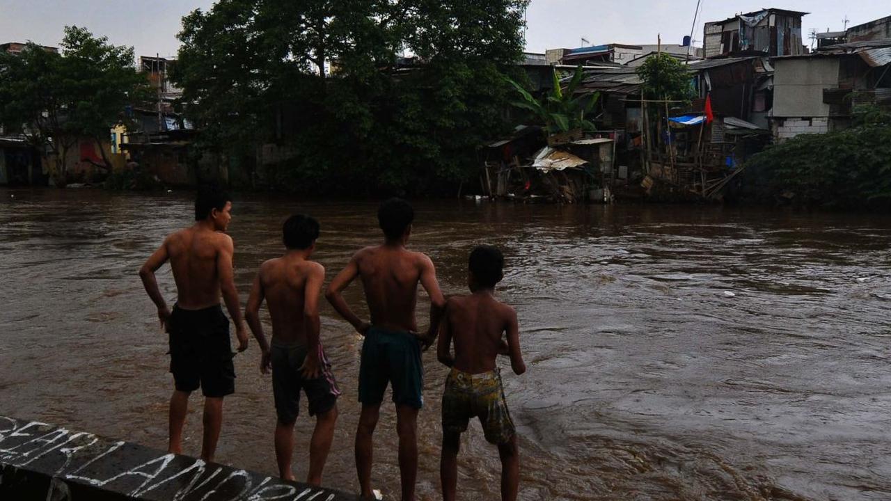 Sejumlah anak bersiap melompat pada aliran Kali Ciliwung yang mengalir deras di kawasan Bukit Duri-Manggarai, Jakarta, Selasa (2/7/2024). Derasnya arus sungai serta tingginya debit air tak menghalangi anak-anak untuk tetap bermain di Kali Ciliwung.&nbsp;M