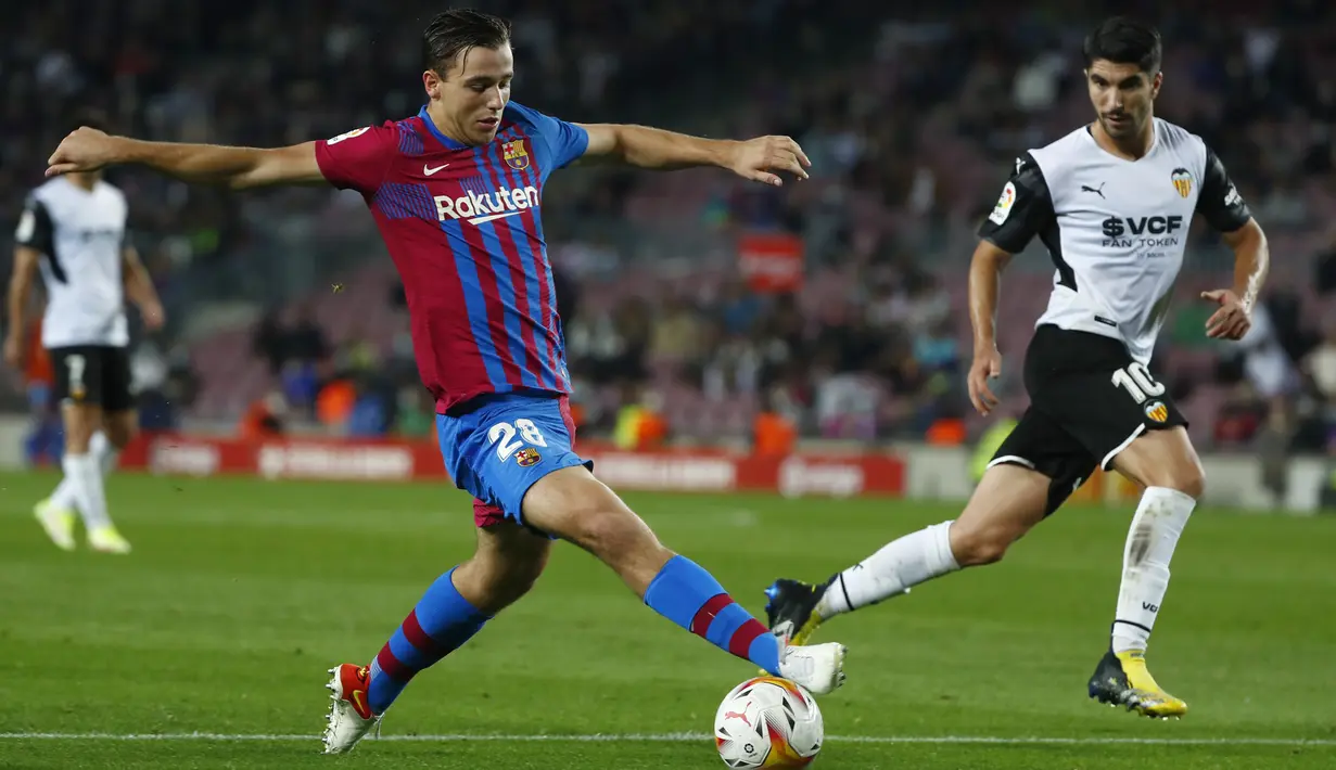 Pemain Barcelona, Nico mengontrol bola dari kawalan pemain Valencia, Carlos Solerpada pertandingan lanjutan La Liga Spanyol di stadion Camp Nou,Spanyol, Senin (18/10/2021). Kemenangan ini mengantar Barcelona berada di peringkat ketujuh klasemen dengan 15 poin. (AP Photo/Joan Monfort)