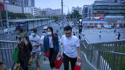 Orang-orang berjalan melintasi jembatan penyeberangan di lingkungan dengan dugaan kasus virus corona di Beijing (15/9/2021). China memperketat penguncian dan meningkatkan pesanan untuk pengujian massal di kota sepanjang pantai timurnya di tengah lonjakan kasus COVID-19. (AP Photo/Mark Schiefelbein)