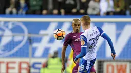 Pemain Wigan Athletic, Jay Fulton berebut bola bola dengan pemain Manchester City, Fernandinho pada babak kelima Piala FA di DW Stadium, Senin (19/2). Manchester City City disingkirkan oleh tim divisi ketiga Wigan Athletic dengan skor 1-0. (AP/Rui Vieira)