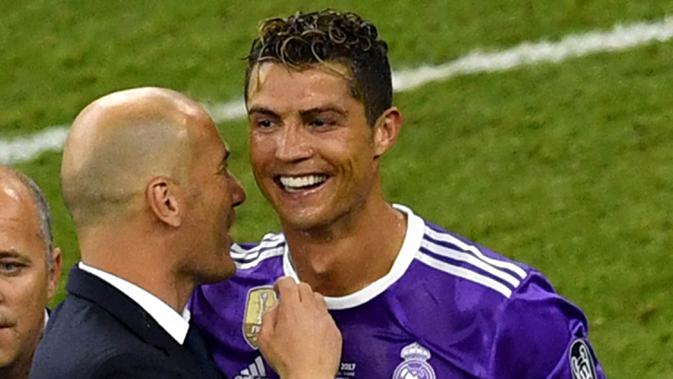 Pelatih Real Madrid, Zinedine Zidane bersama Cristiano Ronaldo melakukan selebrasi usai mengalahkan Juventus pada laga final Liga Champions di Stadion Millennium, Cardiff, Sabtu (3/06/2017). Real Madrid menang 4-1. (AFP/Ben Stansall)