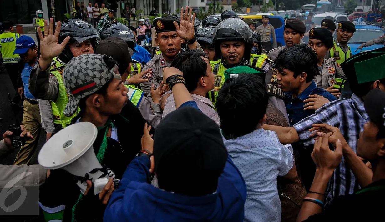 Aktivis HMI beradu mulut dengan polisi saat melakukan demo di Jalan Cikini, Jakarta, Sabtu (8/10). Mereka menuntut Basuki Tjahaja Purnama (Ahok) mempertanggungjawabkan pernyataannya yang dinilai mencederai kitab suci Alquran. (Liputan6.com/Faizal Fanani)