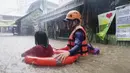 Penyelamat membantu seorang gadis saat mengarungi banjir yang disebabkan Topan Rai di Kota Cagayan de Oro, Filipina selatan, Kamis (16/12/2021). Puluhan ribu orang sedang dievakuasi ke tempat yang aman ketika Topan Rai mendekati pada Kamis (16/12). (Philippine Coast Guard via AP)