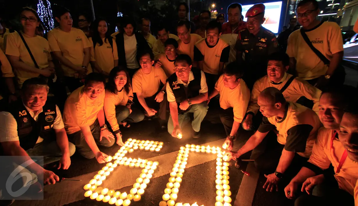Sejumlah karyawan Artha Graha mengikuti aksi "Earth Hour" dengan menyalakan lilin membentuk angka 60 di kawasan SCBD Jakarta saat lampu-lampu di kawasan itu mulai dipadamkan selama satu jam pada Sabtu malam (19/3/2016). (Foto: Istimewa)